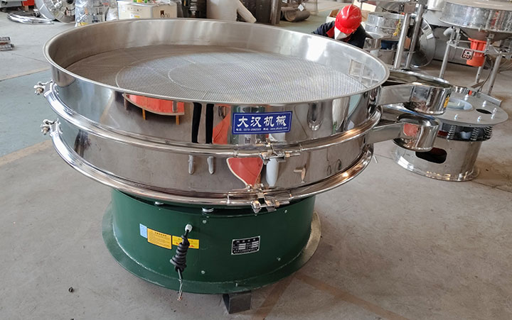 An open-top stainless steel vibrating screen machine showing the internal mesh surface, illustrating quality factors such as aperture uniformity, tension, and edge construction.