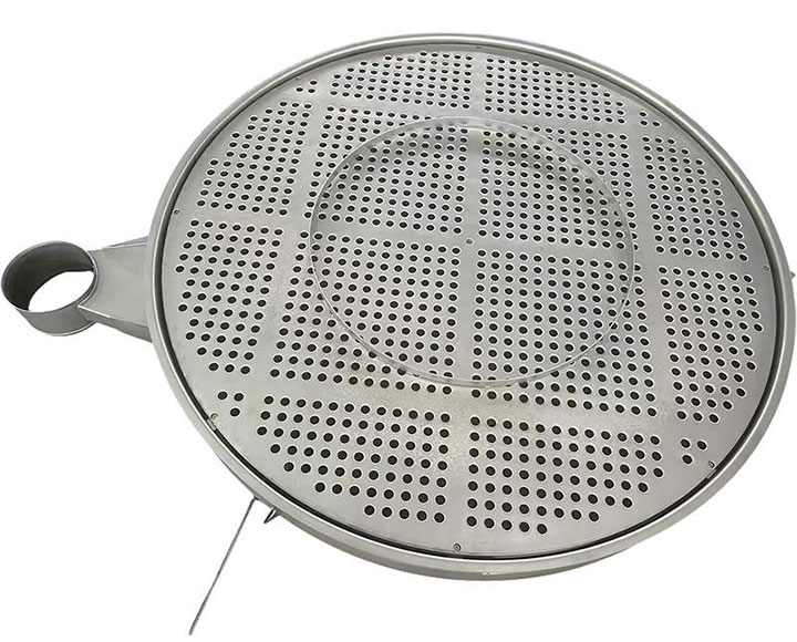Engineer inspecting stainless steel polymer screening mesh discs next to an extruder screen changer.