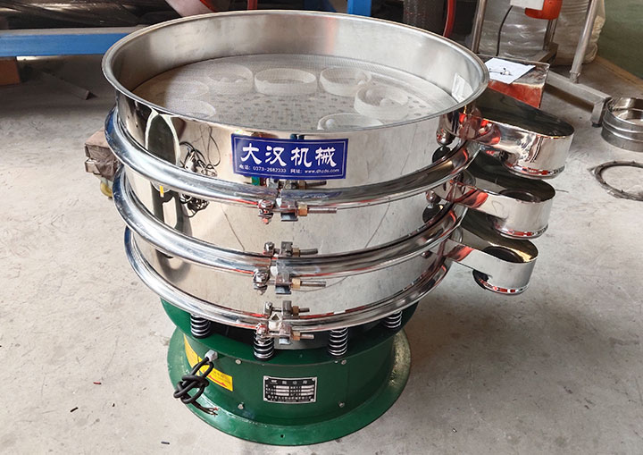 Multi-deck stainless steel vibrating screen showing the screen mesh, maintenance clamps, and discharge outlets for particle separation.